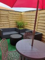 a table and chairs with an umbrella on a patio at Studio avec mezzanine in Gujan-Mestras