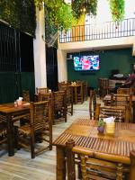 un restaurante con mesas y sillas de madera y TV en Loma Alta Hotel Boutique, en Polo