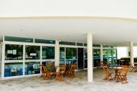 Luxo à Beira-Mar - Flats no Carneiros Beach Resort في بريا دوس كارنيروس: مجموعة من الكراسي والطاولات خارج المبنى