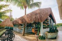 a restaurant with a straw roof and palm trees at Cactus Lodge Pipa in Pipa