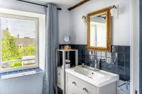 a bathroom with a sink and a mirror at Maison Alfred et Agatha in Pleudihen-sur-Rance