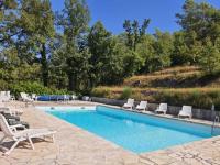 a swimming pool with chairs and a table at La ferme de Manon in Montferrat