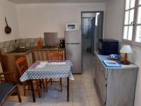 a kitchen with a table and a refrigerator at La ferme de Manon in Montferrat