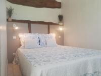 a bedroom with a bed with white sheets and pillows at La ferme de Manon in Montferrat