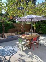 a wooden table with chairs and an umbrella at Maison en Provence in Salon-de-Provence