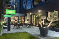 Un restaurante con mesas y sillas frente a un edificio. en Doubletree By Hilton Plovdiv Center, en Plovdiv