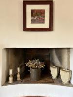 a fireplace with vases and a picture on the wall at Sur le Pont in Vaison-la-Romaine