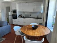 a kitchen with a wooden table and white cabinets at Sur le Pont in Vaison-la-Romaine