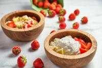 two wooden bowls of food with strawberries and whipped cream at Ubud Mykonos in Agios Ioannis Mykonos