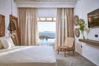 a bedroom with a bed and a view of the ocean at Ubud Mykonos in Agios Ioannis Mykonos
