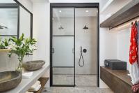 a bathroom with a glass shower stall and a sink at Ubud Mykonos in Agios Ioannis Mykonos