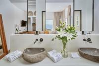 a bathroom with two sinks and a vase of flowers at Ubud Mykonos in Agios Ioannis Mykonos