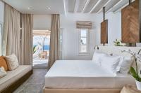 a white bedroom with a large bed and a window at Ubud Mykonos in Agios Ioannis Mykonos