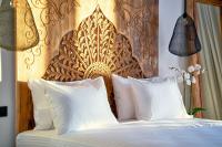 a bed with white pillows and a wooden headboard at Ubud Mykonos in Agios Ioannis Mykonos