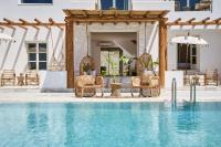 a pool with chairs and umbrellas next to a house at Ubud Mykonos in Agios Ioannis Mykonos