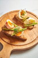 a wooden plate with eggs on top of toast at Ubud Mykonos in Agios Ioannis Mykonos