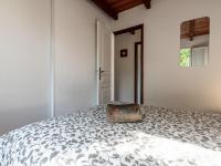a white bedroom with a bed with a bag on it at Holiday Home La Pinede - SAG171 by Interhome in Sagone