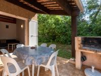 a table and chairs on a patio with a fireplace at Holiday Home La Pinede - SAG171 by Interhome in Sagone