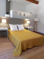a bedroom with a yellow bed with two tables and two lamps at domaine de Capoulade in Narbonne