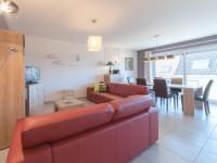 a living room with a red couch and a dining room at Apartment Zeebries by Interhome in Bredene