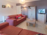a living room with a red couch and a table at Apartment Zeebries by Interhome in Bredene