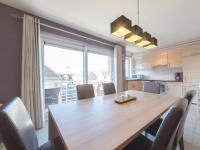 a kitchen and dining room with a wooden table and chairs at Apartment Zeebries by Interhome in Bredene