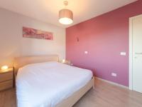 a bedroom with a white bed and a purple wall at Apartment Zeebries by Interhome in Bredene