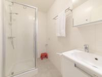 a white bathroom with a shower and a sink at Apartment Zeebries by Interhome in Bredene