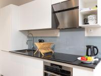 a kitchen with white cabinets and a black counter top at Apartment Plasenn by Interhome in Saint Malo