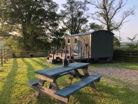 a picnic table and a playground in front of a trailer at The Peacock Shepherds Hut at Hafoty Boeth in Corwen