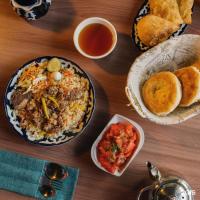 een tafel met een bord eten en een kom soep bij Gagarin Capsule Hotel in Alma-Ata