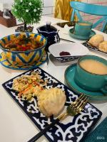 een tafel met borden eten en een kopje koffie bij Gagarin Capsule Hotel in Alma-Ata