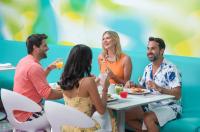 Temptation at The Tower Cancún Resort - All Inclusive - Adults Only في كانكون: مجموعة من الأشخاص يجلسون حول طاولة ويتناولون الطعام