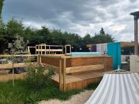 a wooden deck with a hot tub in a yard at La Salamandre de l Olivier - Le Laurier in Aubignosc