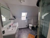a bathroom with a sink and a toilet at Charmant duplex à 500 m de la plage in Barbâtre