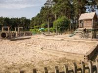 a playground with a play structure and a wooden fence at De Goolder in Bocholt