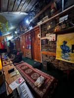 Uma pessoa está sentada no chão em uma sala. em Old Brahma Homestay em Kalgha