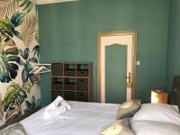 a bedroom with a white bed and a green wall at Hypercentre - Coté Chateau in Blois