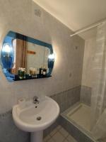 a bathroom with a sink and a mirror and a tub at Chambres d’hôte au Chapeau Claque Cabaret in Gueugnon