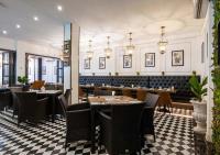 ein Restaurant mit Tischen und Stühlen in einem Raum in der Unterkunft Le Thatluang D'oR Boutique Hotel in Vientiane