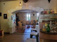 a restaurant with a bar and tables and chairs at Hôtel La Flambée in Bergerac