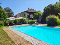 a swimming pool in front of a house at Hôtel La Flambée in Bergerac