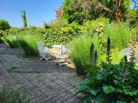 two chairs and a table in a garden at Hôtel La Flambée in Bergerac