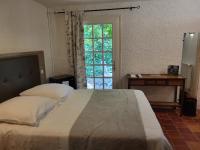 a bedroom with a large bed and a window at Hôtel La Flambée in Bergerac