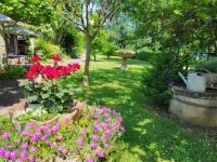 a garden with pink flowers in a park at Hôtel La Flambée in Bergerac