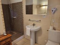 a bathroom with a sink and a shower and a toilet at Hôtel La Flambée in Bergerac