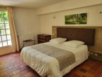 a bedroom with a large bed and a window at Hôtel La Flambée in Bergerac