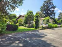 a house with a driveway in front of it at Hôtel La Flambée in Bergerac