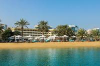 アブダビにあるLe Meridien Abu Dhabi Resortのパラソルとヤシの木があるビーチ、ホテルを提供しています。