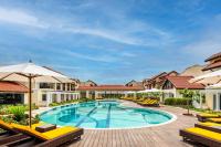 una piscina en un resort con sillas y sombrillas en Fairfield by Marriott Goa Benaulim, en Benaulim